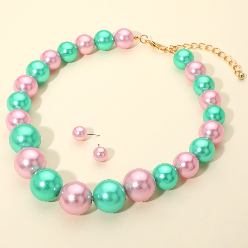 Pink and Green oversized pearl statement necklace set with large round beads and matching stud earrings, displayed on a light cream background.