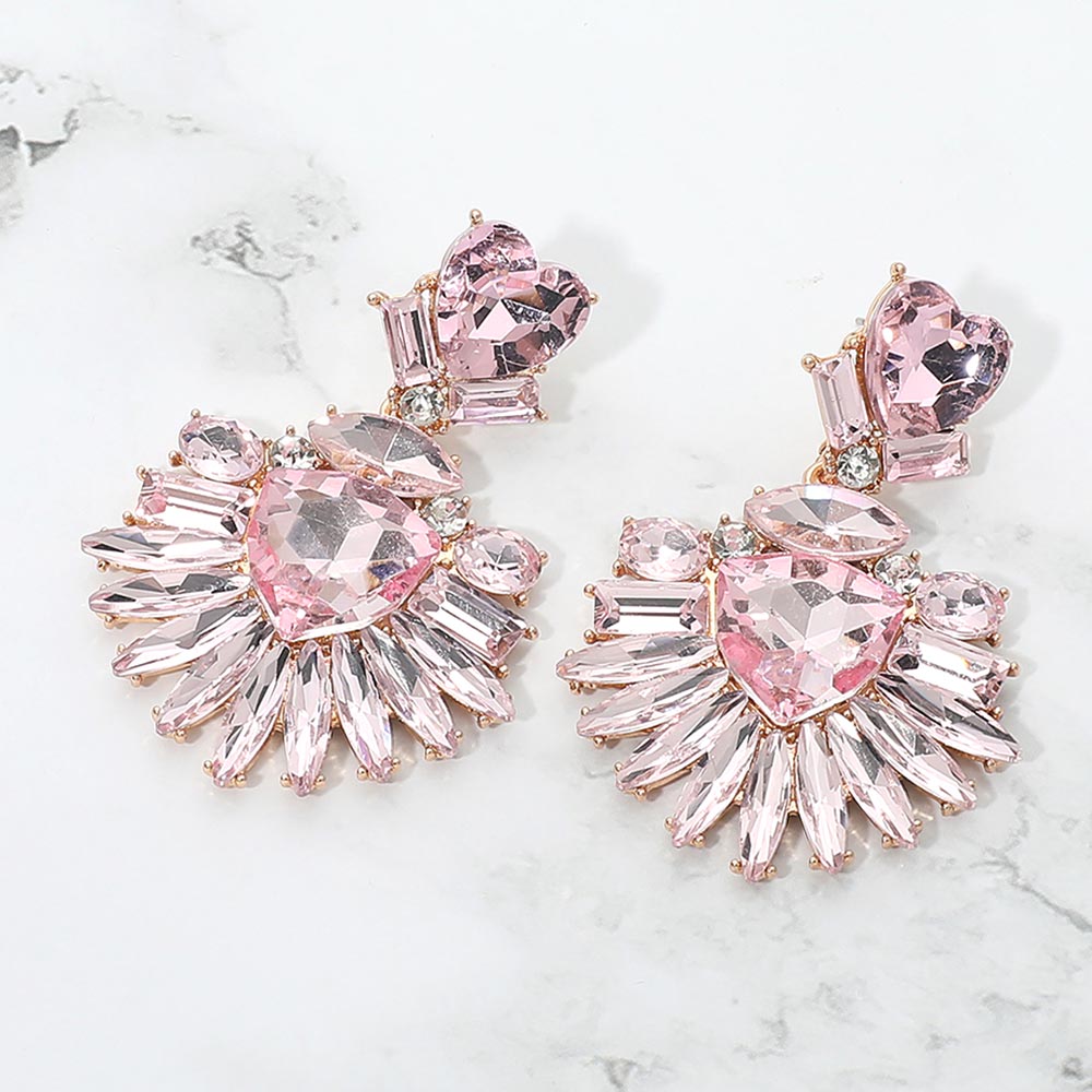 Pink Heart Crystal Fan pageant and prom earrings on gold displayed on a white marble background