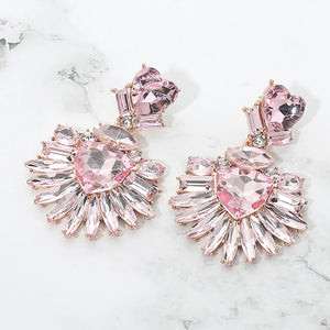 Pink Heart Crystal Fan pageant and prom earrings on gold displayed on a white marble background