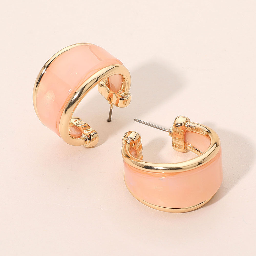 Pink marbled resin half hoop earrings with wide chunky statement design trimmed in gold for fun fashion and everyday wear on a light beige background