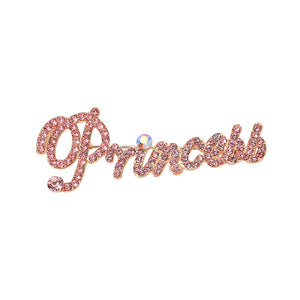 Gold-tone “Princess” brooch with pink crystals covering flowing, connected script lettering and a large looping capital P, measuring approximately 2.8 inches wide by 1.1 inches tall, displayed on a white background.