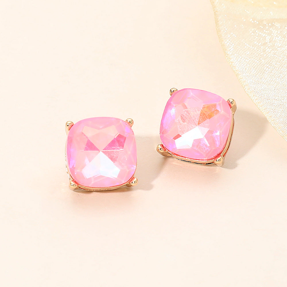 Pink square cushion stud earrings on gold on light beige background
