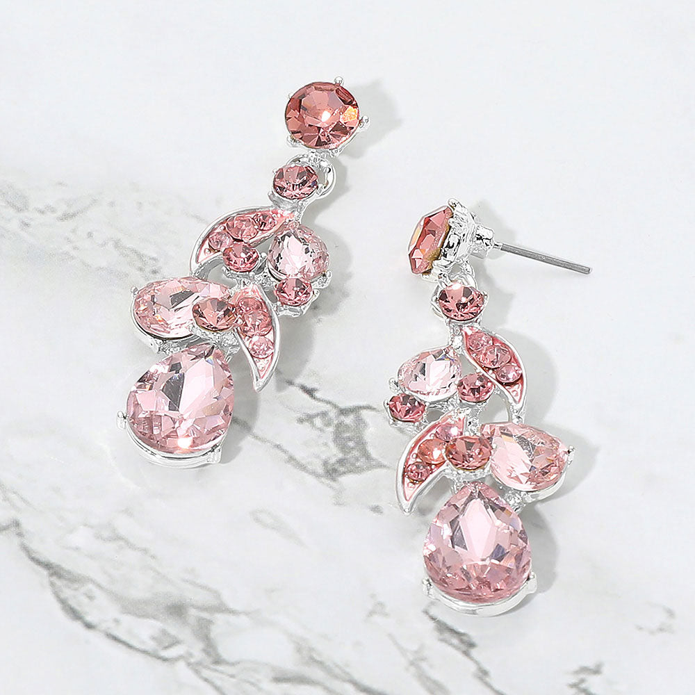 Pink teardrop crystal cluster drop prom and formal earrings on silver on white marble background