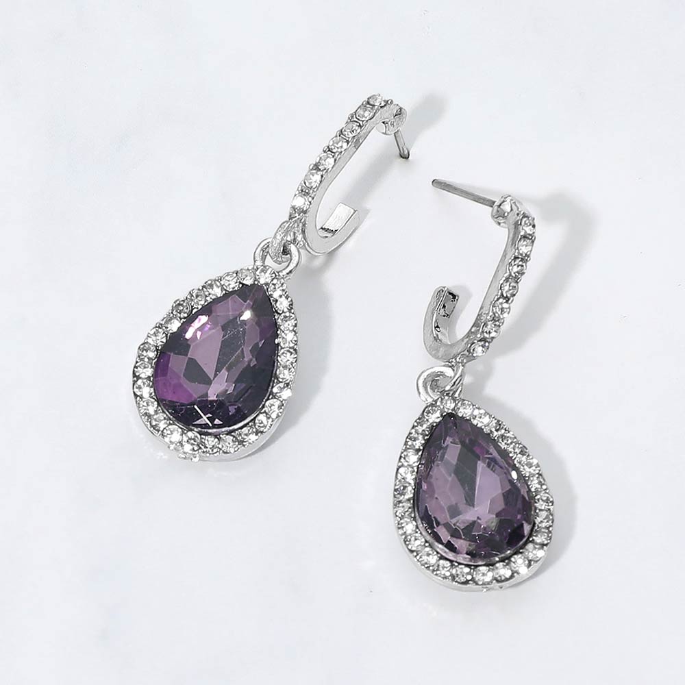 Purple teardrop rhinestone trim dangle earrings on silver on white background