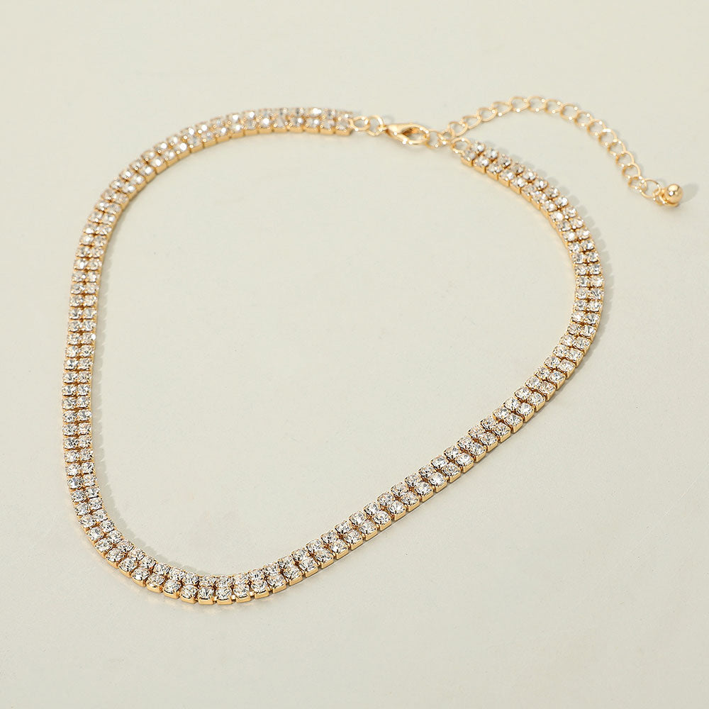 Gold double row rhinestone necklace with two slim crystal strands for formal occasions on a white background