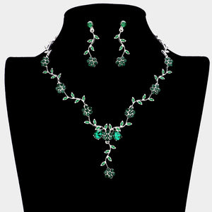Emerald green crystal prom necklace set on silver with matching earrings displayed on a black mannequin bust on a white background.