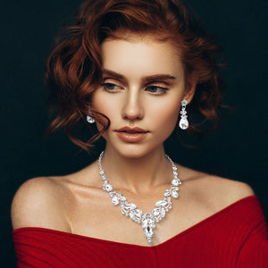 Model wearing Clear marquise stone cluster necklace with teardrop rhinestone design, matching earrings, on a black background, for prom or formal events
