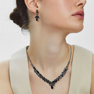Woman wearing black marquise teardrop rhinestone cluster necklace set with matching earrings, all silver backed for prom and formal wear on a plain white background.  