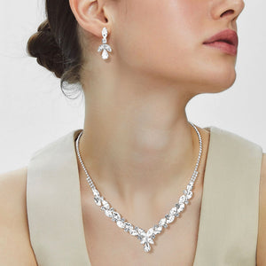Woman wearing clear marquise teardrop rhinestone cluster necklace set with matching earrings, all silver backed for prom and formal wear on a plain white background.  