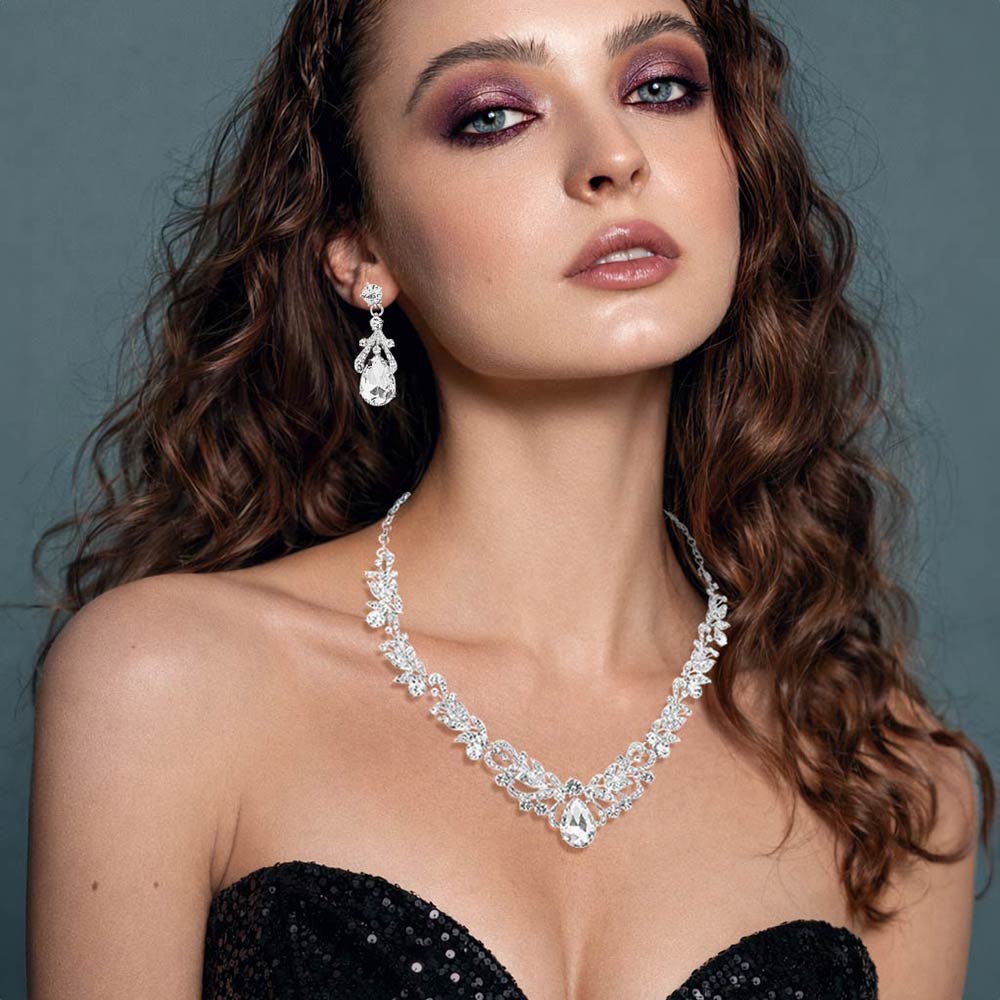 Model wearing Clear teardrop leaf crystal statement necklace set with matching earrings in a silver setting