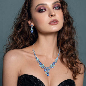 Model wearing light sapphire teardrop leaf necklace set on silver with matching earrings for prom and evening wear