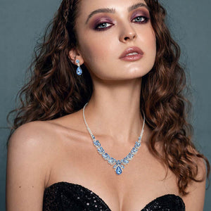 Model wearing Sapphire blue teardrop marquise prom necklace set on silver with matching earrings displayed