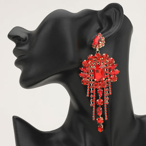 Long 4.6" red chandelier fringe earrings on a black mannequin ear — dramatic crystal statement jewelry for pageant, prom, weddings, and evening events.