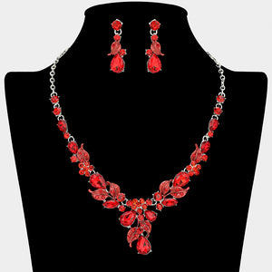 Ruby red crystal teardrop leaf necklace and earring set on silver for formal events and pageants on a black mannequin bust on a white background.