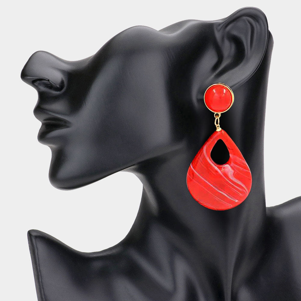 Red resin teardrop cutout dangle earrings on a black mannequin ear on a white background— bold modern 3.25" fashion statement jewelry.