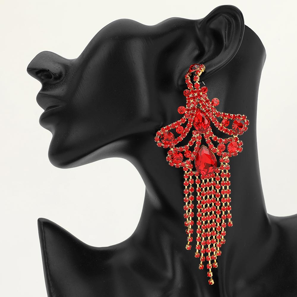A large ornate Red crystal statement earring on gold with cascading bead fringe and clear crystal accents on a black earring mannequin.
