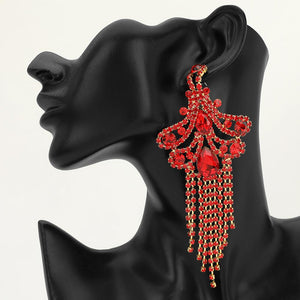 A large ornate Red crystal statement earring on gold with cascading bead fringe and clear crystal accents on a black earring mannequin.