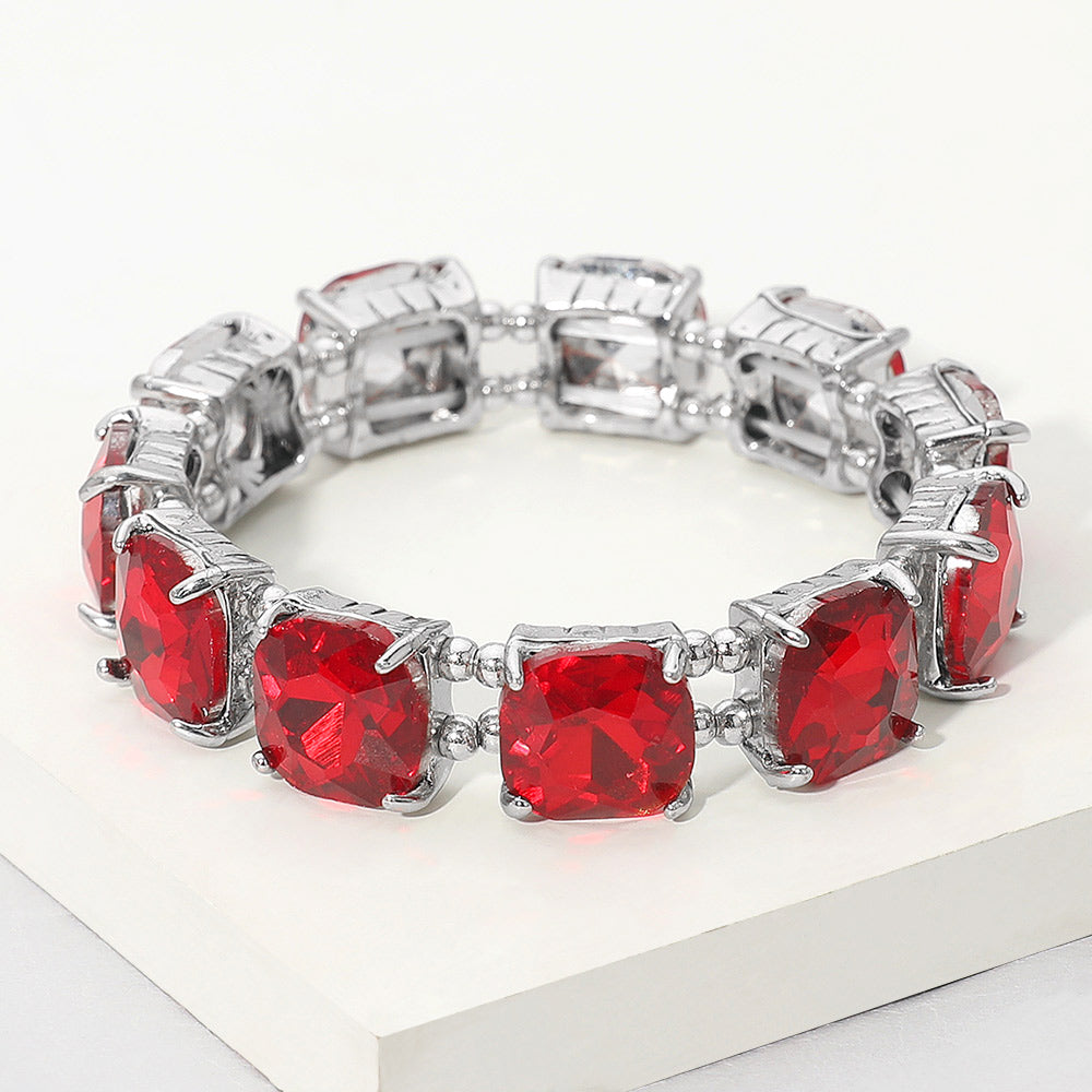 Red cushion square stone stretch evening bracelet on silver, bold statement bracelet for evening wear on a white background