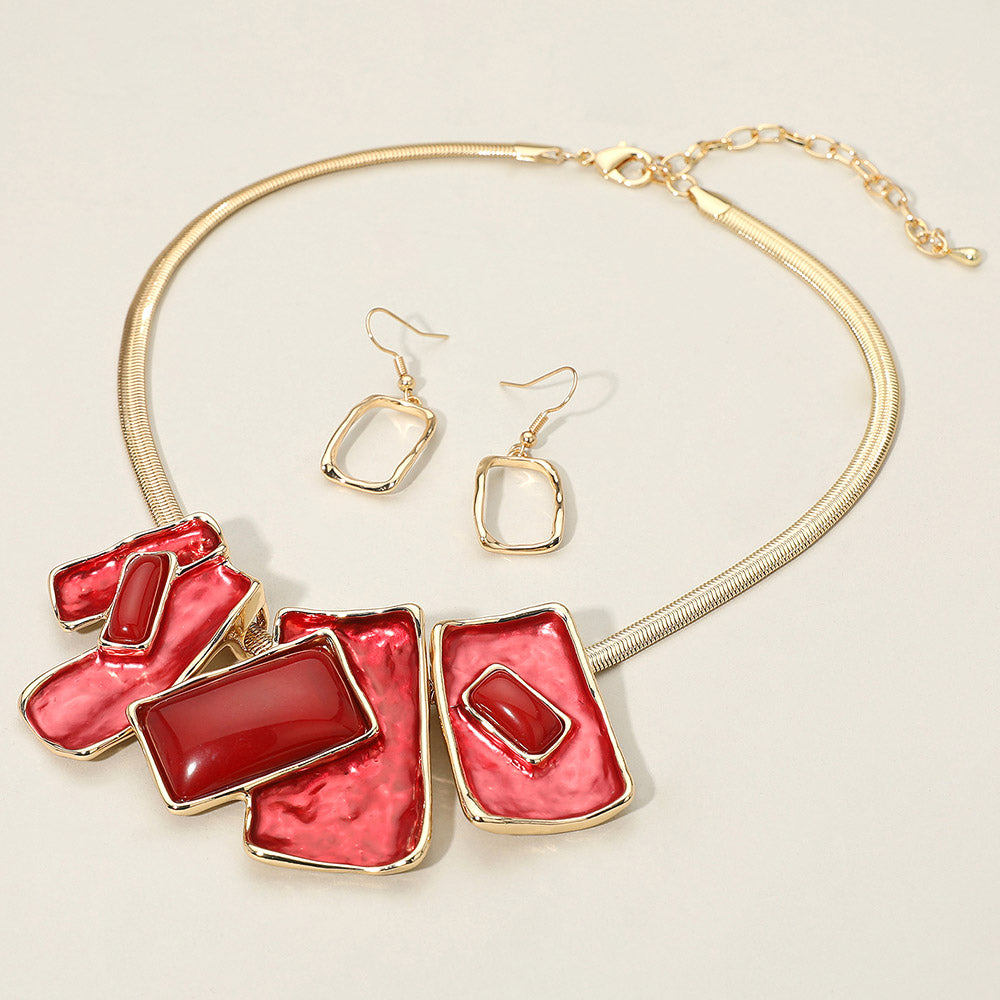 Red geometric enamel beaded necklace set with matching earrings for prom or pageant style. It is on a ivory background.