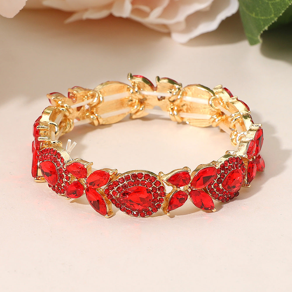 Red marquise rhinestone bracelet on gold stretch band for prom or pageants on a peach background