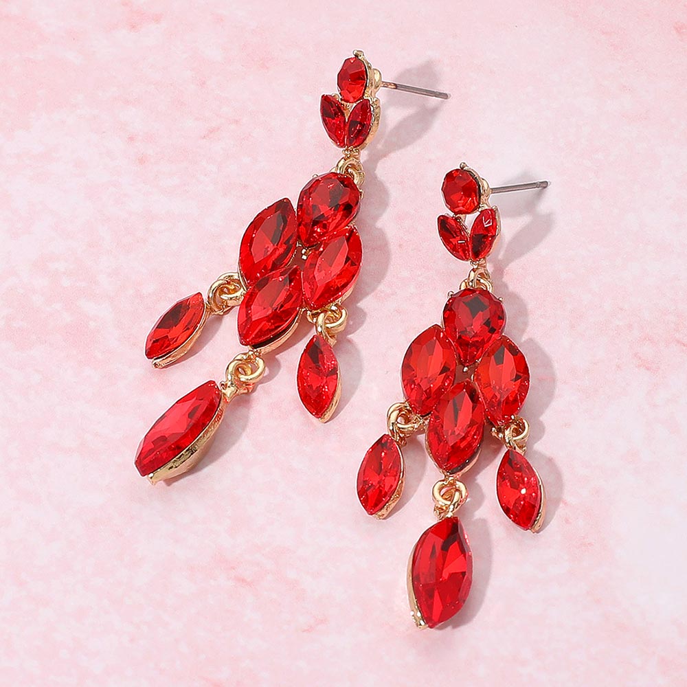 Red gemstone with three link dangle earrings on a pink background