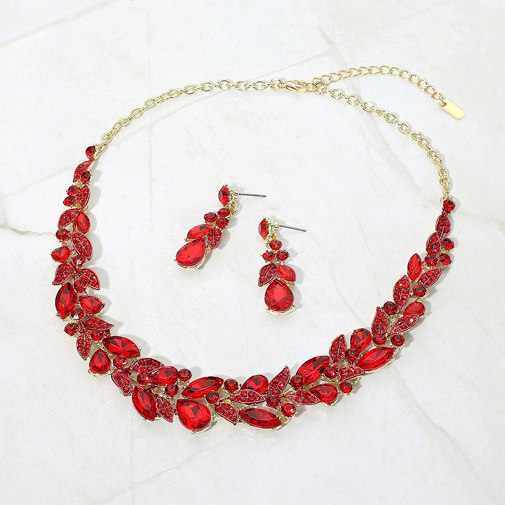 Red marquise and teardrop crystal cluster formal necklace set on gold with matching earrings on white marble background