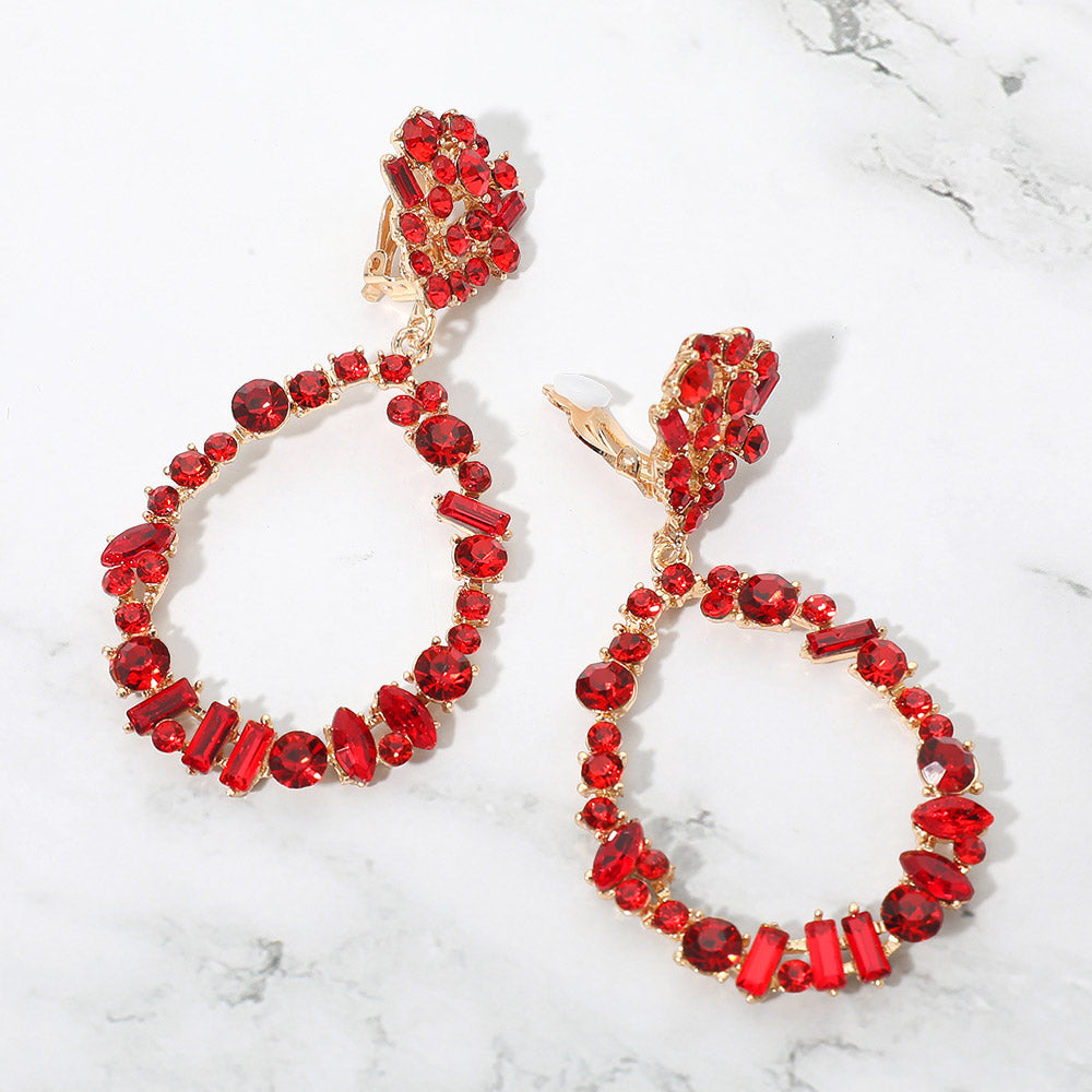 Red mixed stone cluster open teardrop clip-on pageant earrings on gold on a white background