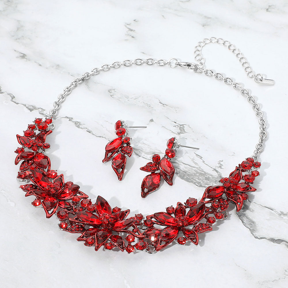 Red jewelry set with necklace and earrings on a marble background
