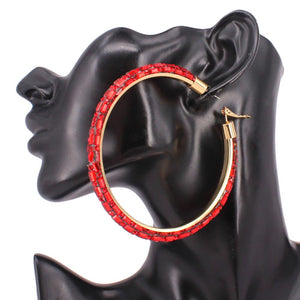 Red oversized baguette rhinestone hoop earrings on gold with omega back on a black mannequin ear