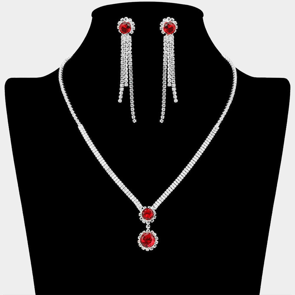 Red round CZ crystal drop necklace set with silver-tone rhinestone chain and matching long dangle earrings on a black display background