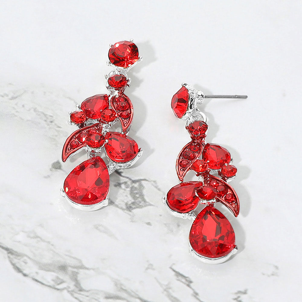 Red teardrop crystal cluster drop prom and formal earrings on silver on white marble background