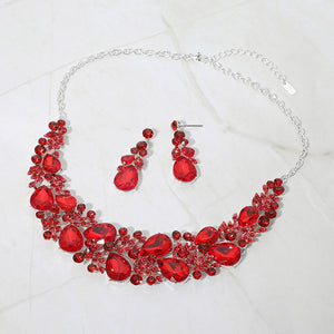 Red teardrop leaf branch statement necklace set on silver on a white marble background