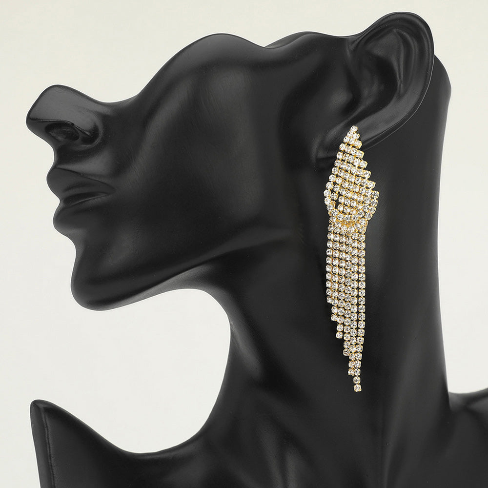 Long clear gold rhinestone cascade fringe drop earrings on gold on a black mannequin — sparkling tassel statement jewelry for weddings, prom, and evening glam.