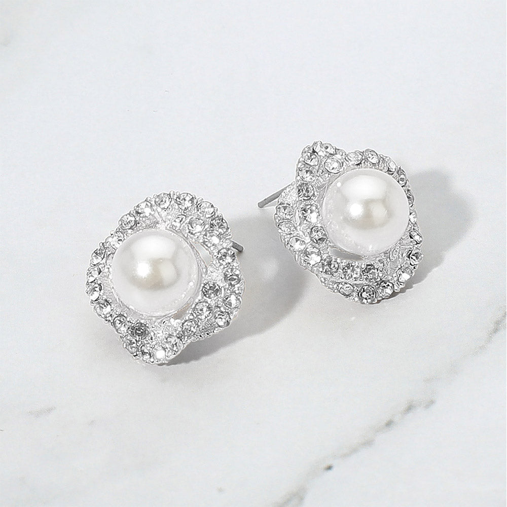 White pearl stud earrings with rhinestone trim for weddings, pageants, or elegant daily wear on a grey and white granite background