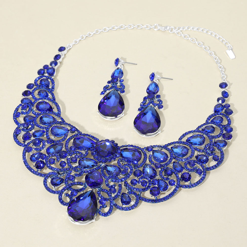 Royal blue sapphire teardrop statement collar necklace and earring set on silver for pageant or prom evening wear on an ivory background