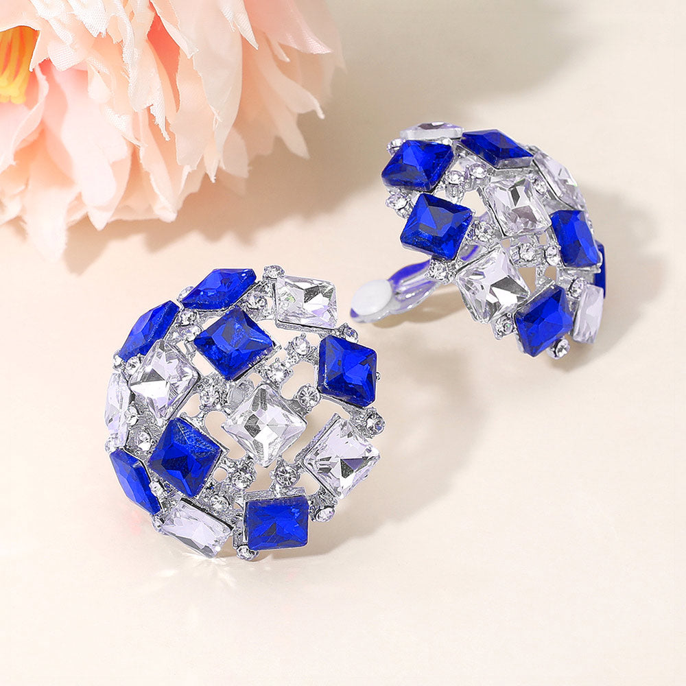Royal blue square stone cluster dome clip-on earrings with a geometric rhinestone design and silver-tone setting on a light background with flowers