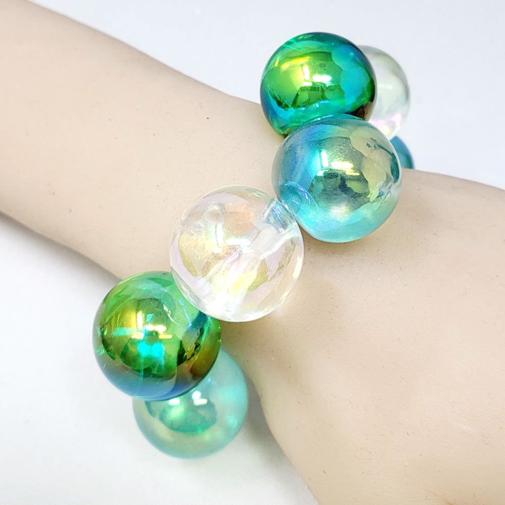 Chunky green and clear iridescent balls/spheres bracelet on a wrist