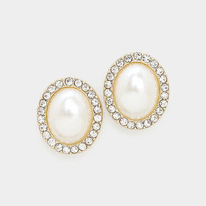 Close-up of cream faux pearl oval stud earrings surrounded by clear rhinestones on gold-tone metal against a white background.