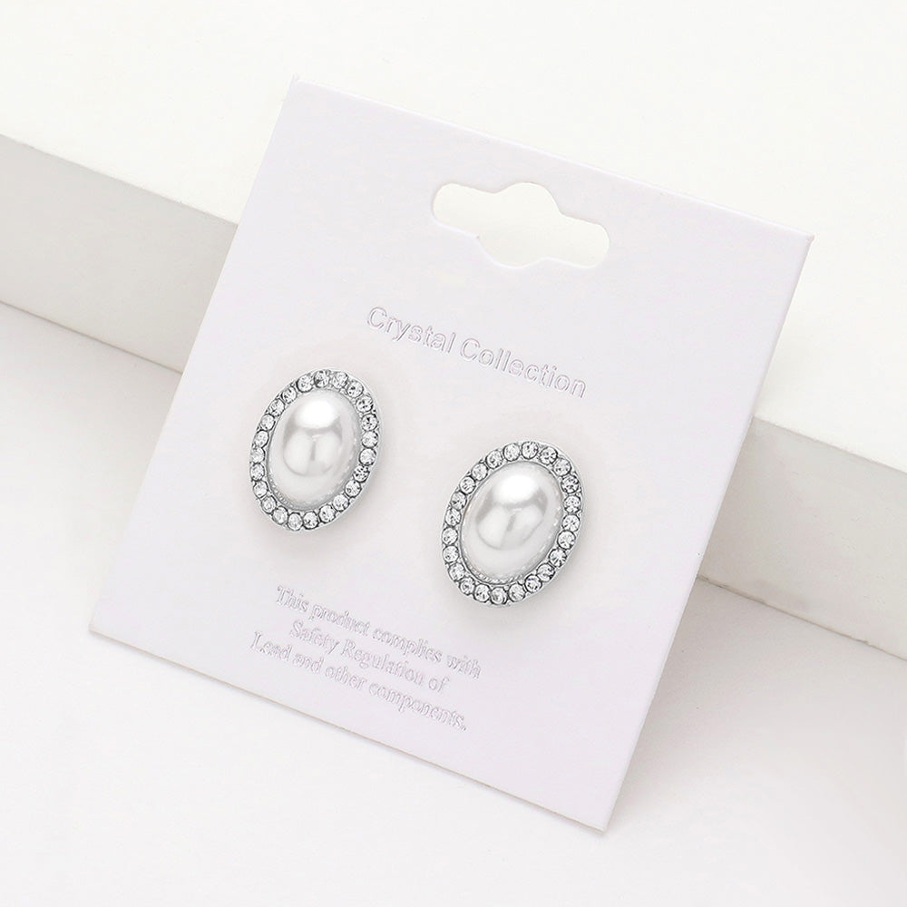 White faux pearl oval stud earrings surrounded by clear rhinestones on silver-tone metal, displayed on a white jewelry card.
