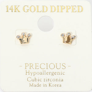 Tiny gold-tone crown stud earrings with clear cubic zirconia accents at the crown tips and a polished metal base. Each earring measures approximately 0.25 by 0.2 inches. Mounted on a cream jewelry display card with gold lettering against a white background.
