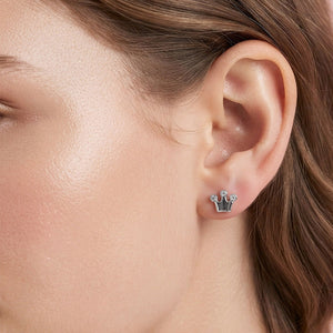 Tiny silver-tone crown stud earrings with clear cubic zirconia accents at the crown tips and a polished metal base. Each earring measures approximately 0.25 by 0.2 inches. Shown here on a model's ear. 