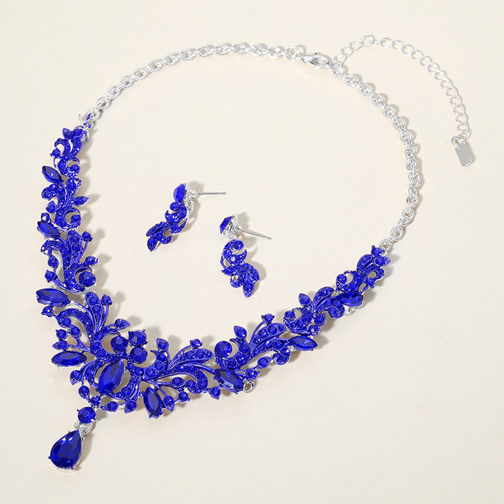 Sapphire royal blue stone cluster prom necklace set on silver with matching earrings on a cream background