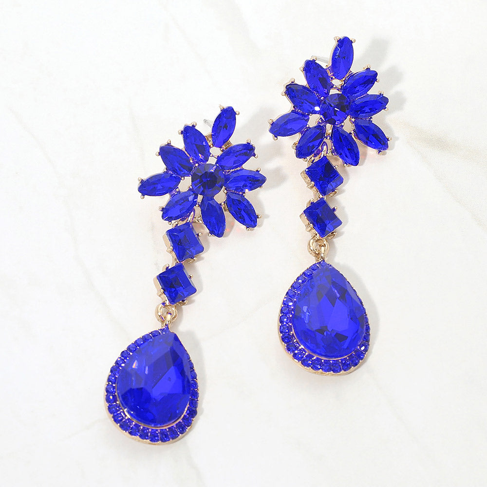 Sapphire royal blue crystal flower teardrop earrings in a gold finish featuring marquise crystal flower tops and large faceted royal blue teardrop drops, displayed on a white background.