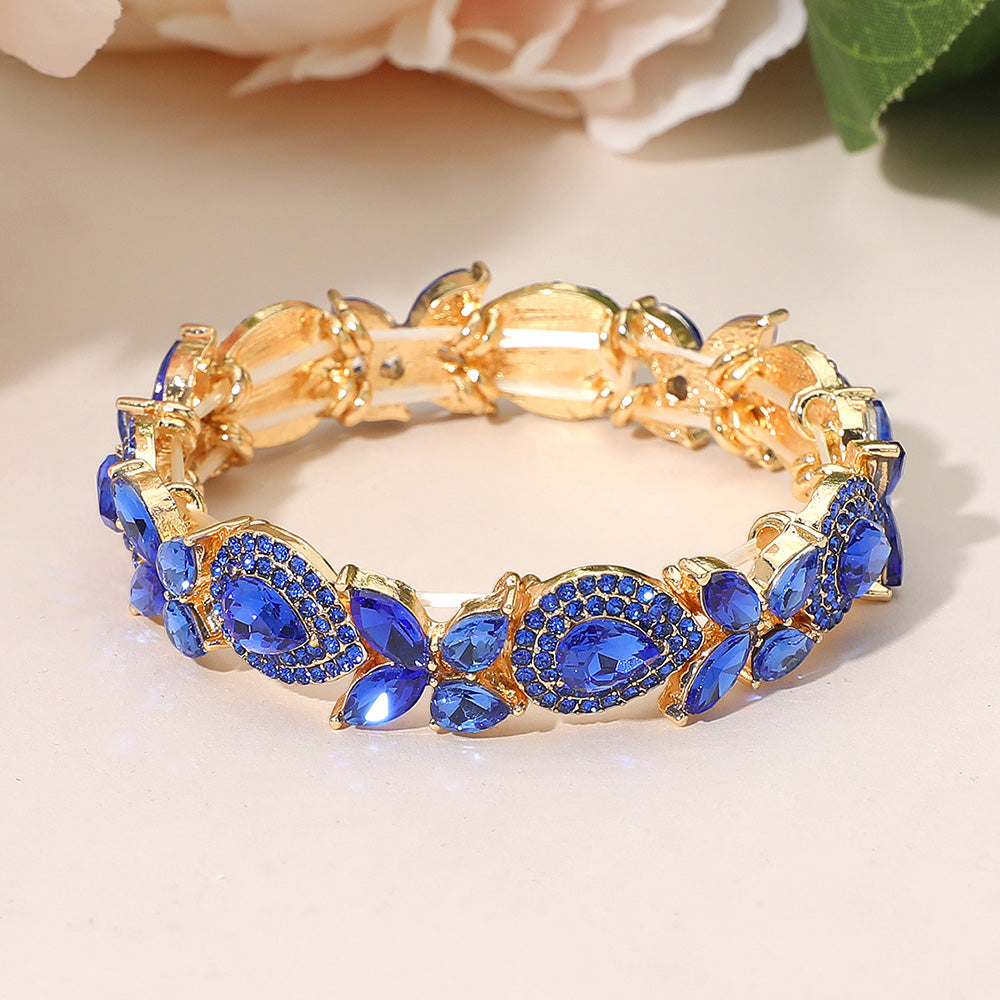 Sapphire blue marquise rhinestone bracelet on gold for pageants and evening wear on a peach background