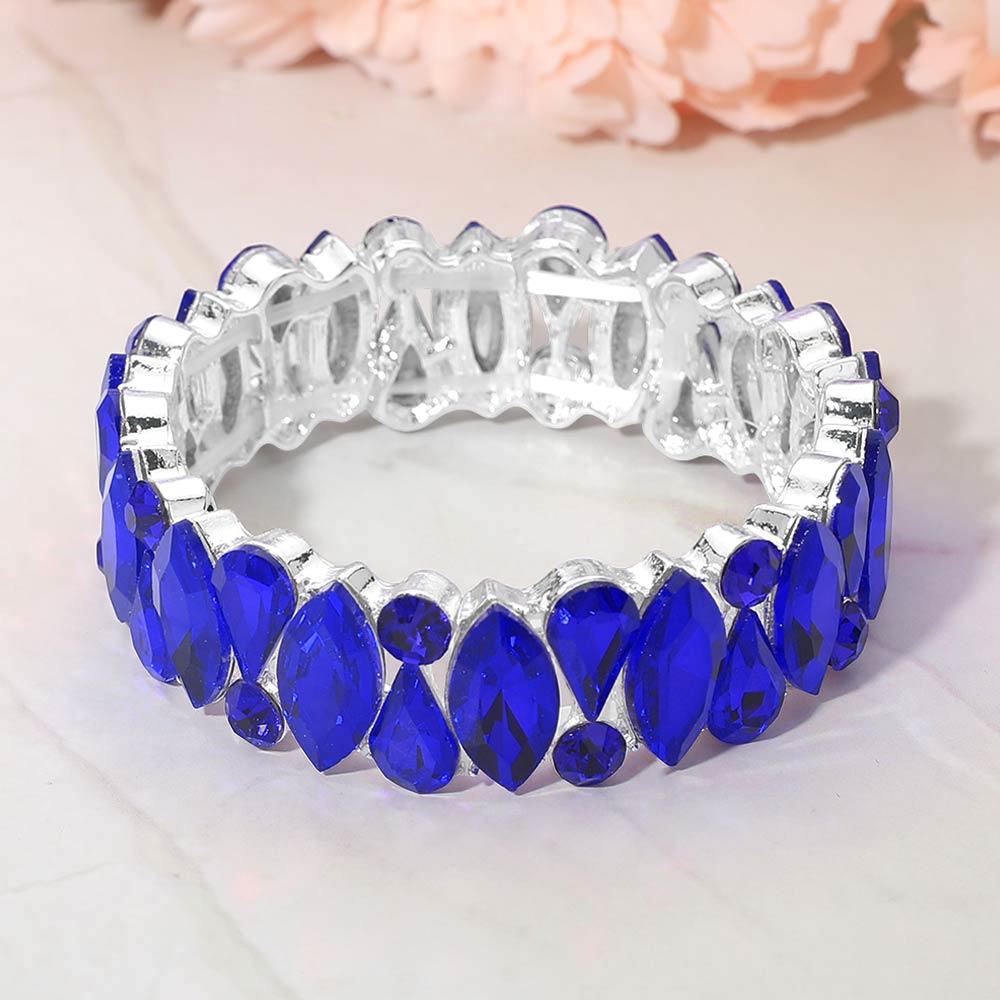 Sapphire royal blue marquise teardrop and round stone cluster stretch bracelet on silver on white marble background