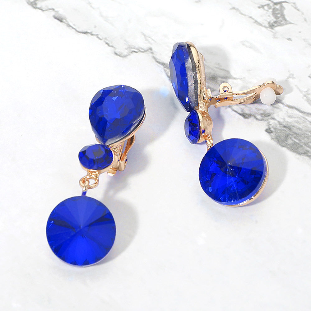 Sapphire royal blue round crystal drop clip-on earrings on gold on white marble background