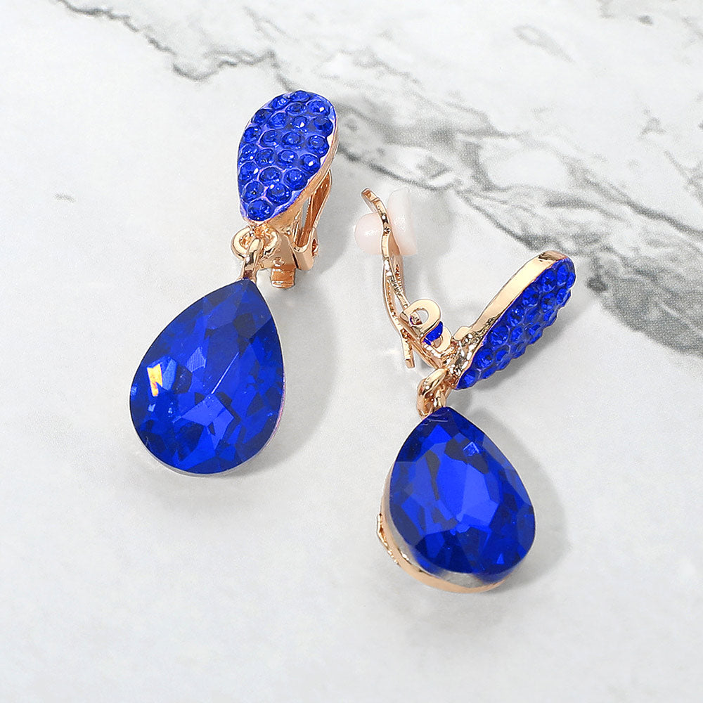 Sapphire royal blue teardrop crystal drop clip-on earrings on gold on white marble background