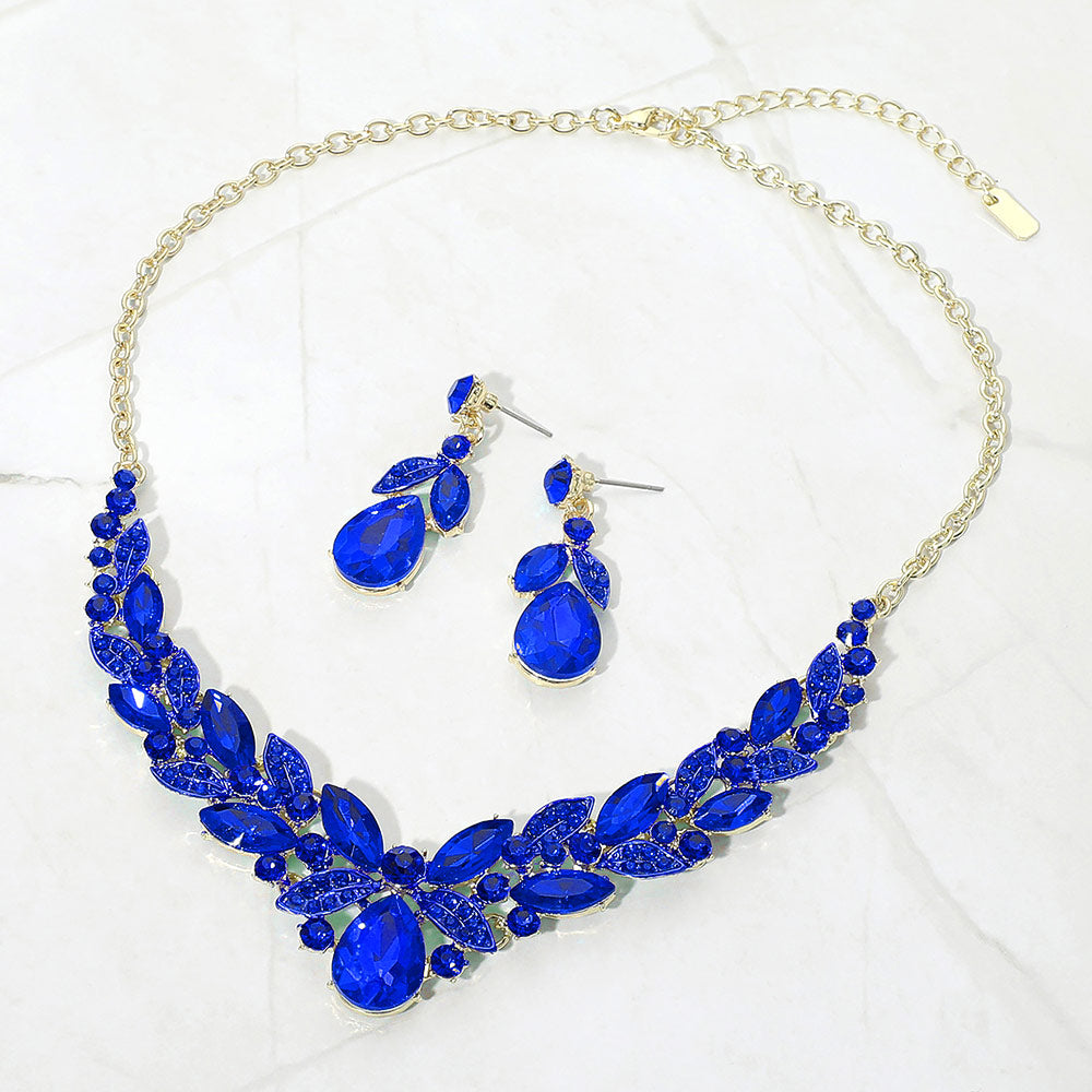 Sapphire Royal Blue teardrop and marquise crystal jewelry set on gold displayed on white marble background
