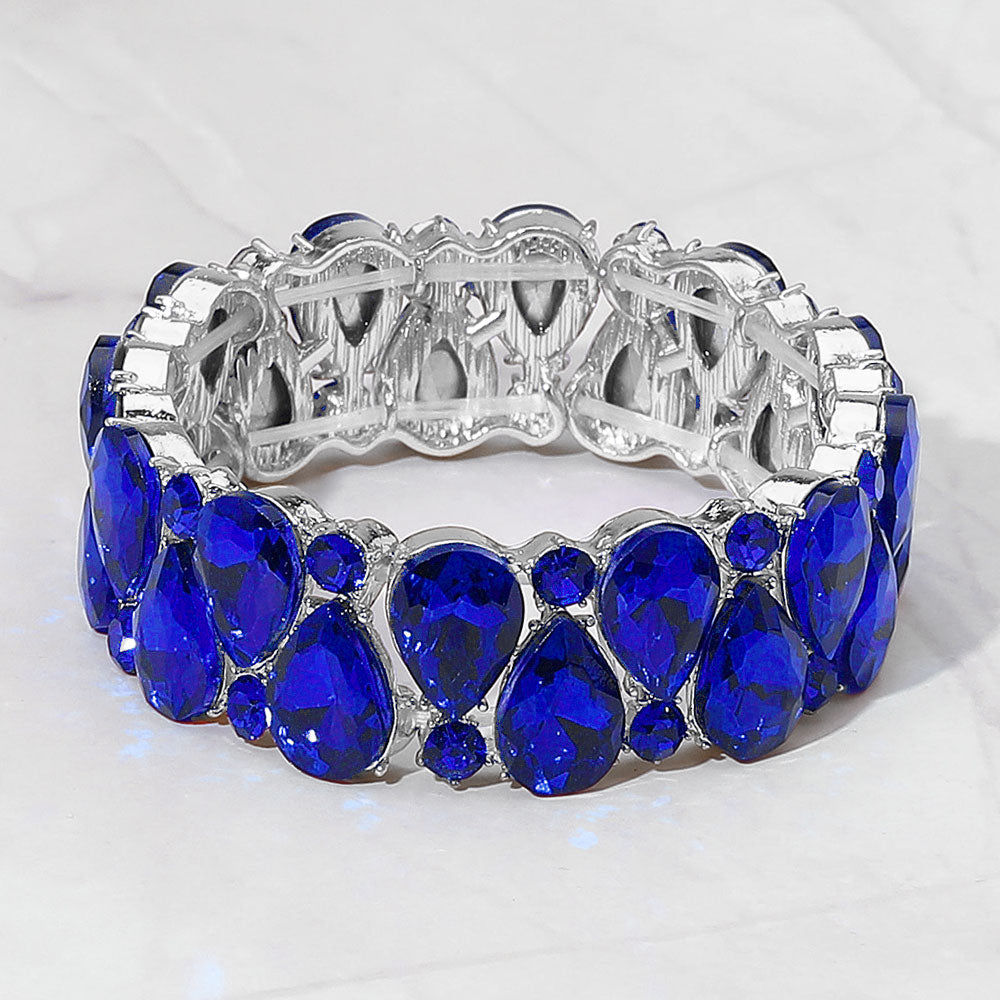 Sapphire royal blue teardrop and round stone cluster stretch bracelet on silver on white marble background
