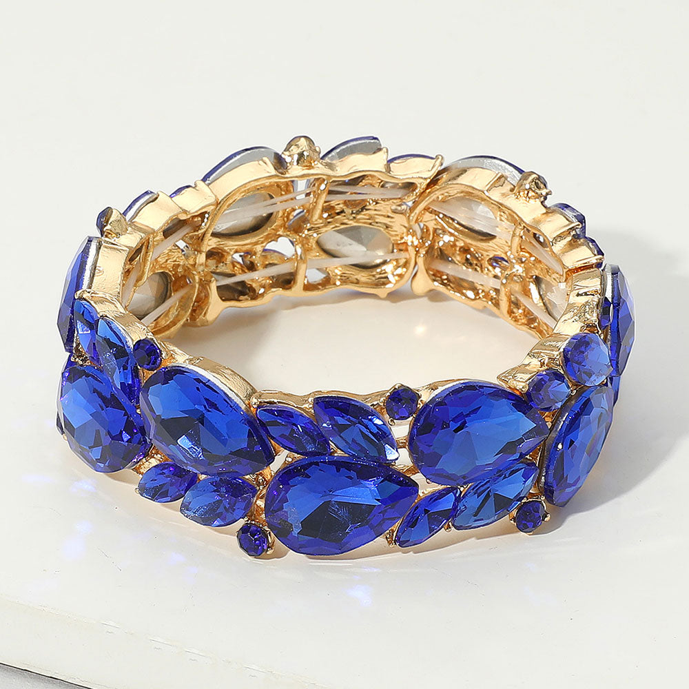 Gold bracelet with blue gemstones on a white background